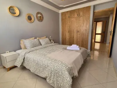 a bedroom with a bed and two mirrors on the wall at My Cosy Place Rabat - Cosy Apartement Avenue de France in Rabat