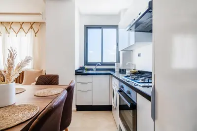 a kitchen with a table and a dining room at Studio Cosy Proche Gares & Mosqué Hassan II in Casablanca