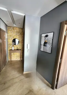 a hallway with a painting on the wall and a table at The Twenty-Six Palmier by IB Signature - Design 1Bedroom Apt with Wifi, Parking, Self check-in, 24 x7 Security - City View with terrace - Walk to Cafes! City Centre, Tram in Casablanca