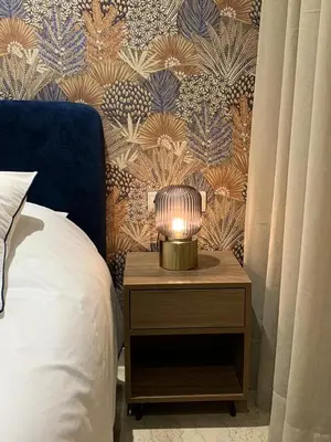 a lamp on a night stand next to a bed at The Twenty-Six Palmier by IB Signature - Design 1Bedroom Apt with Wifi, Parking, Self check-in, 24 x7 Security - City View with terrace - Walk to Cafes! City Centre, Tram in Casablanca