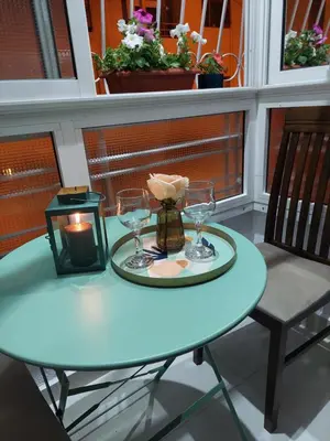 a blue table with a candle and glasses on a balcony at Chabili Appartements in Temara