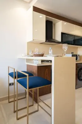 a kitchen with a white counter and blue chairs at Charming & Airy Flat - Perfect for Relaxation in Casablanca