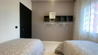 a bedroom with a bed and a door and a window at RABAT RESIDENCE - Apartments in Rabat