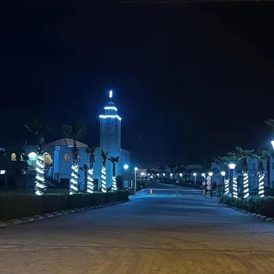 a building with a clock tower at night at Savannah beach sidi Rahal in Dar Hamida