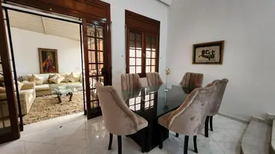 a dining room with a glass table and chairs at Spacious Harhoura Villa: Perfect for Families (5min to Beach) in El Harhoura