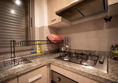 a kitchen counter with a stove and a sink at R101- Cosy and stylish apartment with King Size Bed- Belvédère in Casablanca