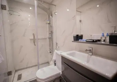 a bathroom with a shower and a toilet and a sink at R101- Cosy and stylish apartment with King Size Bed- Belvédère in Casablanca