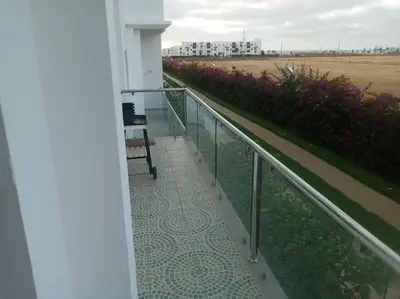 a balcony with a view of a field of flowers at Cocon cozy à Mansouria Mer, piscines et nature in Mansouria