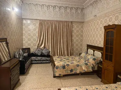 a bedroom with two beds and a dresser at Appartement oulfa in Casablanca
