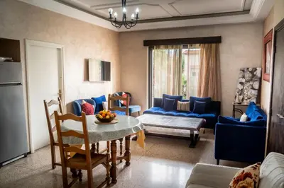 a living room with a table and a blue couch at Grand appartement 3 chambre in Casablanca