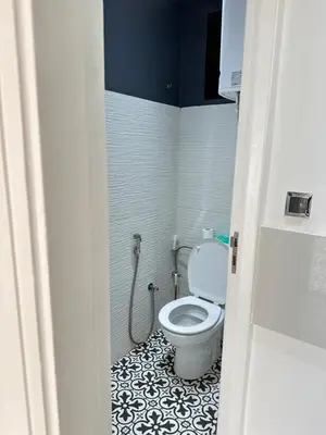 a bathroom with a toilet with a black and white tile floor at Chambre à Agdal Rabat dans un appartement partagé in Rabat