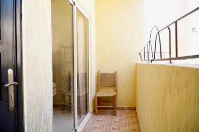 an empty room with a chair and a glass door at Le Calme a Temara in Temara