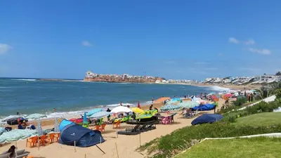 a beach with many tents and people on the beach at Sublime Appart Bouznika Pool&View in Bouznika