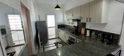 a kitchen with white cabinets and a black counter top at Sublime Appart Bouznika Pool&View in Bouznika