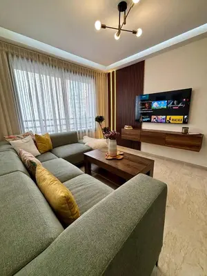 a living room with a couch and a tv at Au centre de Casablanca maarif in Casablanca