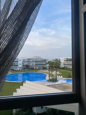 a view of a pool from a window at Appartement sur SIDI Rahal in Casablanca