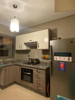 a kitchen with a stainless steel refrigerator and cabinets at Appartement sur SIDI Rahal in Casablanca