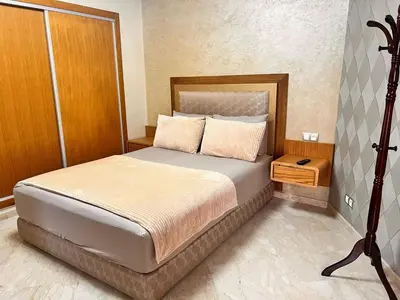 a bedroom with a large bed with a wooden headboard at Studio Cosy Centre Ville Casablanca in Casablanca