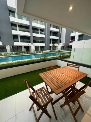 a wooden table and chairs on the balcony of a building at ZS house harhoura vue sur piscine in Temara