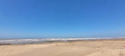 a sandy beach with the ocean in the background at Bel appartement avec vue sur mer Sidi Rahal in Sidi Rahal