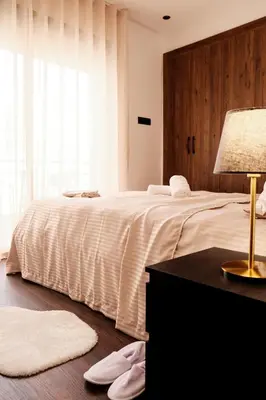 a bedroom with a large white bed and a table with a lamp at New Apartment Casablanca City Center Maarif in Casablanca