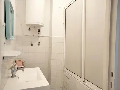 a white bathroom with a sink and a shower at Dar Lamine Duplex in Rabat