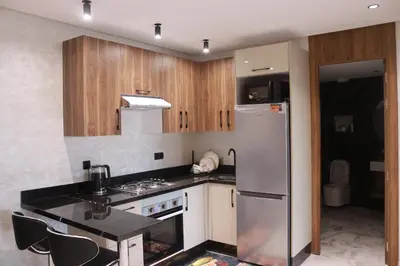 a kitchen with a stainless steel refrigerator and wooden cabinets at LUXE APPARTEMENT in Casablanca