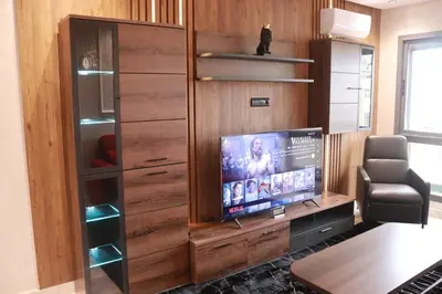 a living room with a tv and a entertainment center at LUXE APPARTEMENT in Casablanca