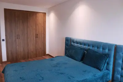 a bedroom with a blue bed and a wooden door at LUXE APPARTEMENT in Casablanca
