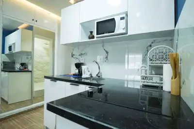 a kitchen with white cabinets and a microwave at Luxury Studio, Coeur de l'Agdal in Rabat