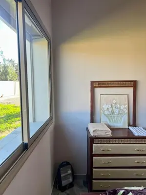 a dresser with a picture on it next to a window at La Casa Blanca • Ecolodge Vert in Oulad Youssef