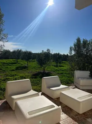 three white couches and chairs sitting on a patio at La Casa Blanca • Ecolodge Vert in Oulad Youssef