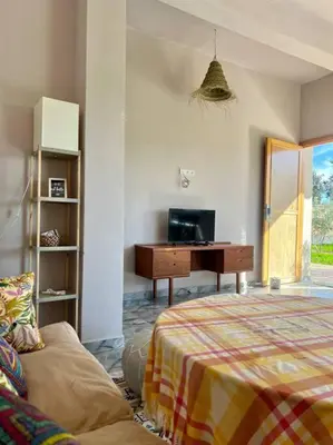a bedroom with a bed and a desk and a table at La Casa Blanca • Ecolodge Vert in Oulad Youssef
