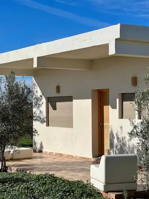 a white house with a bench in front of it at La Casa Blanca • Ecolodge Vert in Oulad Youssef