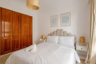 a bedroom with a large white bed with wooden cabinets at TT Holidays 3BR Racine Casablanca in Casablanca
