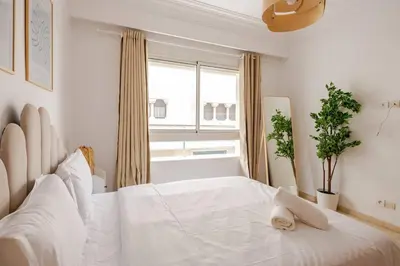a white bedroom with a large white bed and a window at TT Holidays 3BR Racine Casablanca in Casablanca