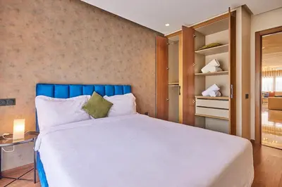 a bedroom with a large bed with a blue headboard at Discover Casablanca Stay in our 3-Bed Gem with Parking in Casablanca