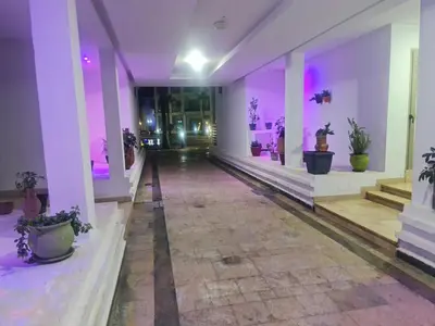 an empty hallway with purple lights and potted plants at superbe appartement vue piscine in Bouznika