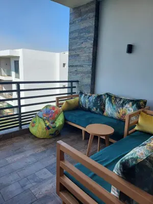 a balcony with two couches and a table at Dahlia Sidi rahal in Sidi Rahal