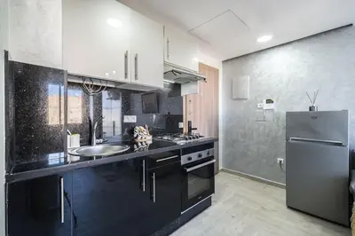 a kitchen with a sink and a refrigerator at Stylish Studio à Ain Sebaa in Casablanca