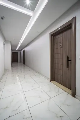 a hallway with a wooden door and a tile floor at Chic Apartment Cosy Stay in Casablanca