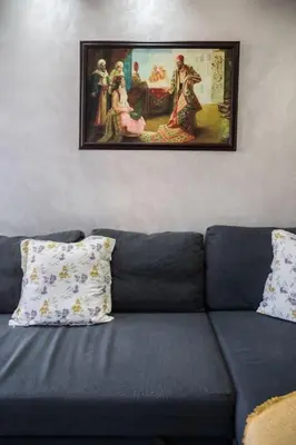 a blue couch with a picture on the wall at Chic Apartment Cosy Stay in Casablanca