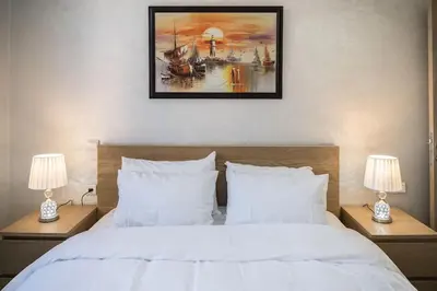 a bedroom with a white bed with two lamps at Chic Apartment Cosy Stay in Casablanca