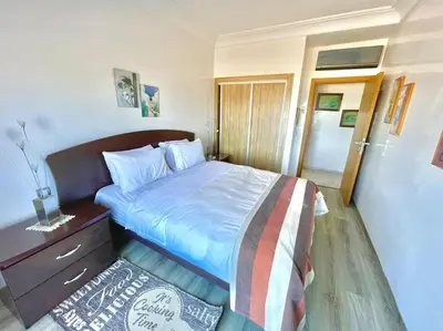 a bedroom with a bed with a wooden head board at Miramar Luxury apartment Front Beach View in Mohammedia