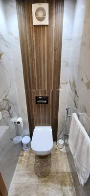 a bathroom with a toilet and a wooden door at Beautiful beachfront apartment in Rabat