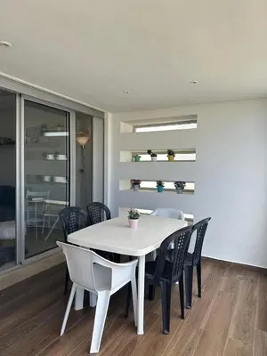 a dining room with a white table and chairs at My Cosy Place - Apartment 2BR - Piscine - Bahia Beach - Bouznika in Bouznika