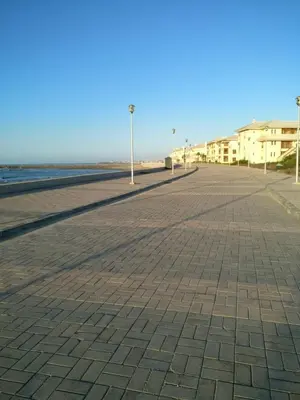 a street with street lights on the beach at My Cosy Place - Apartment 2BR - Piscine - Bahia Beach - Bouznika in Bouznika