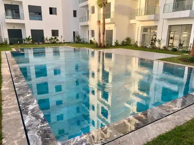 a swimming pool in front of a building at Glorious NOUACEUR in Nouaceur