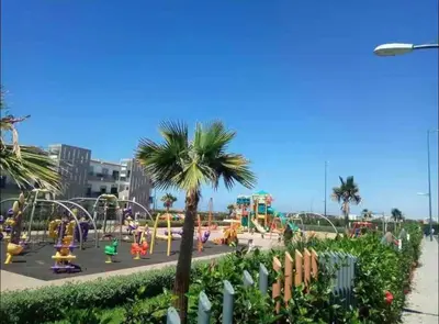 a park with a playground with a roller coaster at Nice Apartment in Blanca Beach in Sidi Rahal