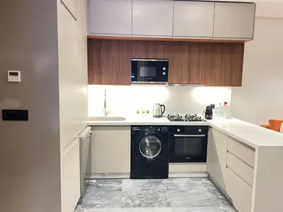 a white kitchen with a washing machine in it at Casa finance city - Anfa Park - CFC in Casablanca